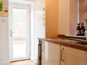 a kitchen with a sink and a counter top at Ghillie Cottage in Cockermouth +11 photos