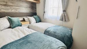 a bedroom with two beds and a window at Luxury 8 Berth Caravan At Butlins Skegness in Skegness +19 photos