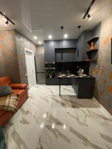 a living room with a kitchen with a marble floor at СВІТЛО ЦІЛОДОБОВО Rent-Kiev metro Chernigivska ViP in Kyiv