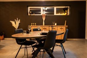 a dining room with a wooden table and chairs at Villa privative Beauraing L'écrin in Beauraing