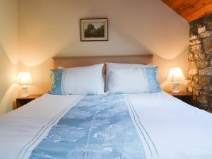 ein Schlafzimmer mit einem großen Bett mit zwei Lampen in der Unterkunft Yarker Lane Cottage in Mickleton