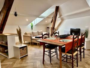 ein Esszimmer mit Tisch und Couch in der Unterkunft Le SILVA Centre ville Lumineux Wifi et Netflix in Périgueux