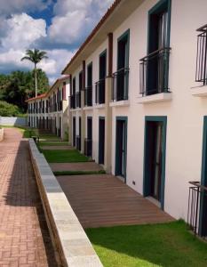 a row of apartment buildings with a sidewalk at Resort Quinta Santa Barbara in Pirenópolis