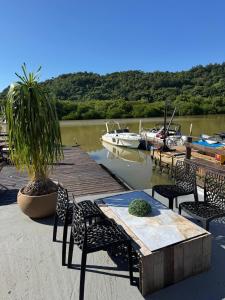 バウネアーリオ・コンボリウーにあるApartmento em Balneário Camboriúの船着き場の横にテーブルと椅子