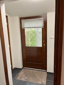 a wooden door in a room with a window at 't Schoenmakershuisje in Epen