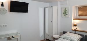 una camera da letto con un letto e una TV a parete di 'PRZY PARKU' pokoje gościnne u zielarki a Stegna