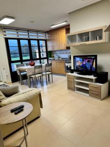 Una sala de estar con un sofá y un televisor. en Apartamento Océano VI, en Villadaíde