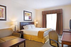een hotelkamer met een bed, een bank en een stoel bij Holiday Inn Express Hotel & Suites - Slave Lake, an IHG Hotel in Slave Lake