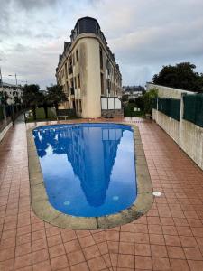 Una gran piscina azul frente a un edificio en Apartamento Océano VI, en Villadaíde
