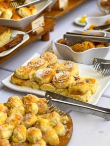 a table topped with plates of pastries and other foods at Castro's Park Hotel in Goiânia +76 photos
