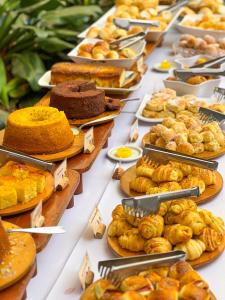 a buffet line with many different types of bread and pastries at Castro's Park Hotel in Goiânia
