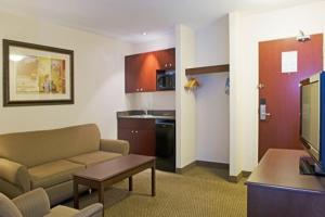 een woonkamer met een bank en een tafel en een keuken bij Holiday Inn Express Hotel & Suites - Slave Lake, an IHG Hotel in Slave Lake
