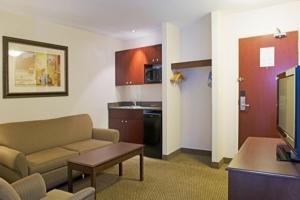 a living room with a couch and a table and a kitchen at Holiday Inn Express Hotel & Suites - Slave Lake, an IHG Hotel in Slave Lake