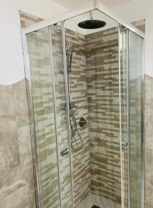 Villetta dei Ginepri في كوستا باراديسو: دش مع باب زجاجي في الحمام
