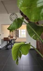 a room with a table and a clock on the wall at Tip Top Vakantie Huis in Vlissingen