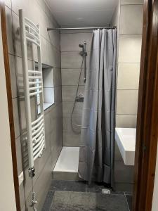 a bathroom with a shower curtain and a sink at 't Schoenmakershuisje in Epen +15 photos