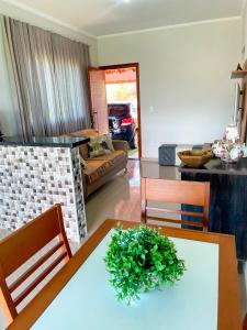 Una sala de estar con una mesa con una planta encima. en Recanto da Serra, en Serra Negra