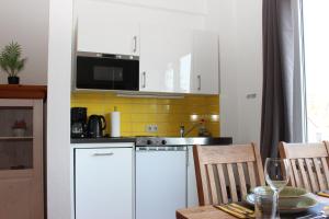 a kitchen with white cabinets and a table with a dining room at Hexnquartier in Braunlage +16 photos