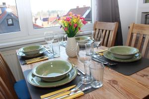 a table with plates and glasses and a vase with flowers at Hexnquartier in Braunlage