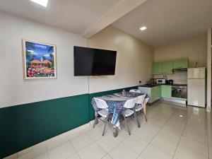 a kitchen with a table with chairs and a flat screen tv at F2 PAPEETE CITY CENTER in Papeete +6 photos