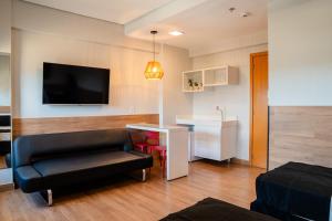 a living room with a couch and a table and a television at i5 Hotel Águas Claras in Brasilia