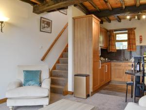 a living room with a staircase and a kitchen at Doddick Chase Cottage - Uk1363 in Threlkeld