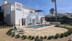 a house with a swimming pool in front of it at Stunning Villa with Pool & View near beach in Budens