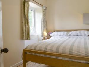 a bedroom with a bed with a window and a bed sidx sidx sidx at Winscott Cottage in Pyworthy +5 photos