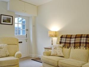 a living room with a couch and a chair at Jasmine Cottage in Keswick