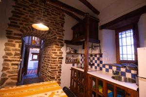 kuchnia ze zlewem i ceglaną ścianą w obiekcie La Casa del Nogal w mieście Güéjar-Sierra