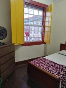 a bedroom with a bed and a window at Hospedaria Vó Helena in Paracatu