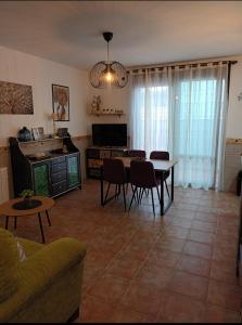 Una sala de estar con una mesa y sillas y un televisor. en El Retoño, en El Bosque 10 fotos más