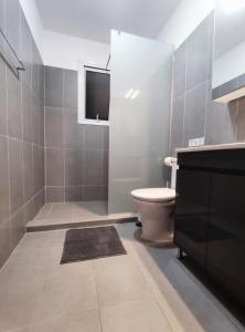 a bathroom with a toilet and a television in it at Pantelia Apartment Paralimni in Paralimni