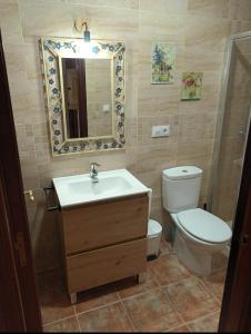 Un baño con inodoro, lavabo y espejo. en El Retoño, en El Bosque
