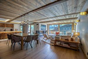 a kitchen and living room with a table and chairs at Les Chalets de La Clusaz - Appartement Le Faon in La Clusaz