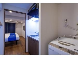 a bathroom with a sink and a bed in a room at Condominium Resort Naha Living Inn Asahibashiekima - Vacation STAY 92450v in Naha +55 photos