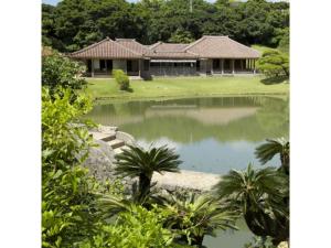 a house with a pond in front of it at Condominium Resort Naha Living Inn Asahibashiekima - Vacation STAY 92450v in Naha
