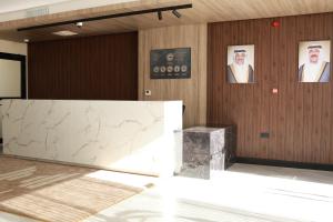 a lobby with a marble counter and pictures on the wall at BHomed Shaab in Kuwait