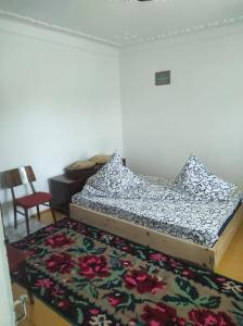 a bed in a room with a rug at Complex de pensiuni si casute -Hangu , Bicaz in Buhalniţa