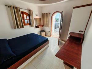 a bedroom with a bed and a table and a window at Ghazala hotel dahab in Dahab
