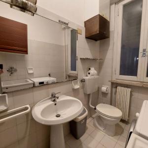 a white bathroom with a sink and a toilet at Camera "La Rosa" in Pistoia