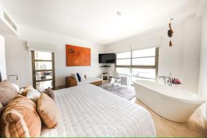 Un dormitorio con una cama grande y una bañera. en La Amada Residences Private Beach Getaway with Pools & Gym, en Cancún