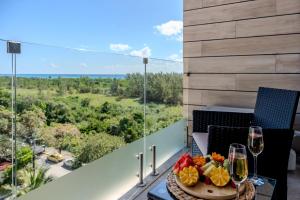 a table with wine glasses and fruit on a balcony at Sea Tower by Casago in Playa del Carmen