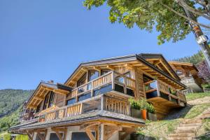 a large log home with a large deck at Les Chalets de La Clusaz - Appartement le Renne in La Clusaz