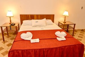 a bed with two towels in the shape of hearts at Hotel Pacífico Talara in Talara