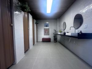 a hallway with a sink and mirror in a bathroom at Chalé 1 in Itacaré