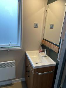 拉特斯Mobil home 55 -8 personnes的带水槽、镜子和窗户的浴室