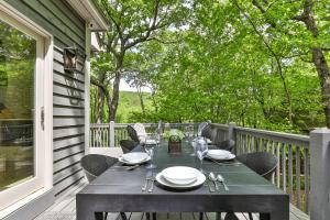 a dining table on a porch with a tableablish at Robins Nest at Big Canoe - Big Canoe, GA - Enjoy Peaceful Forest Views, Rack Up a Game of Pool, and Enjoy Game Nights in the Gam in Jasper
