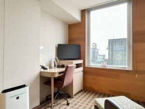 a room with a desk and a tv and a window at Garden Hotel Shizuoka - Vacation STAY 45849v in Shizuoka
