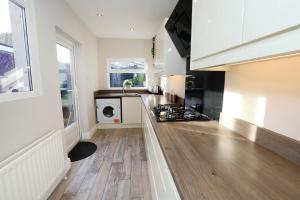 a kitchen with a stove top oven next to a counter at Lisburn Townhouse in Lisburn